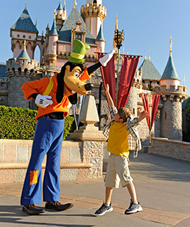 Goofy and a kid high fiving at Disneyland Park