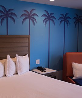 Image of guest room with decorative palm tree wallpaper