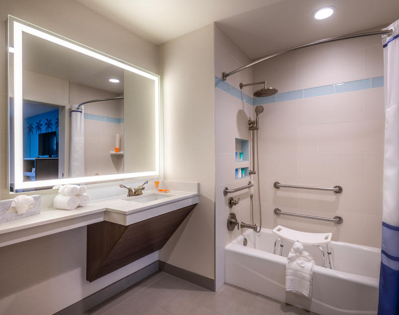 A bathroom with a bathtub, shower, sink, and mirror.