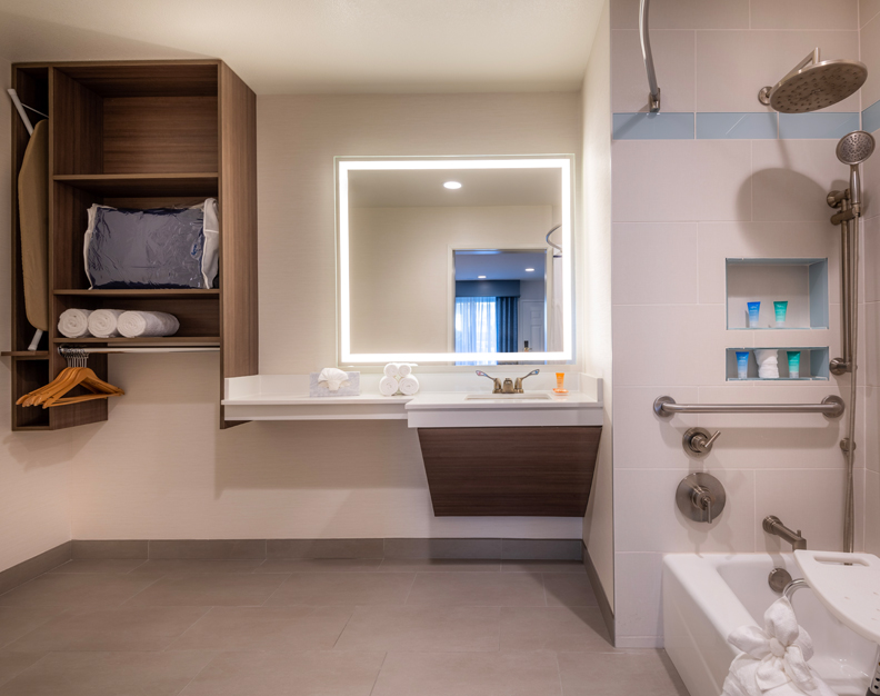 A modern hotel bathroom with a bathtub, sink, and shower.